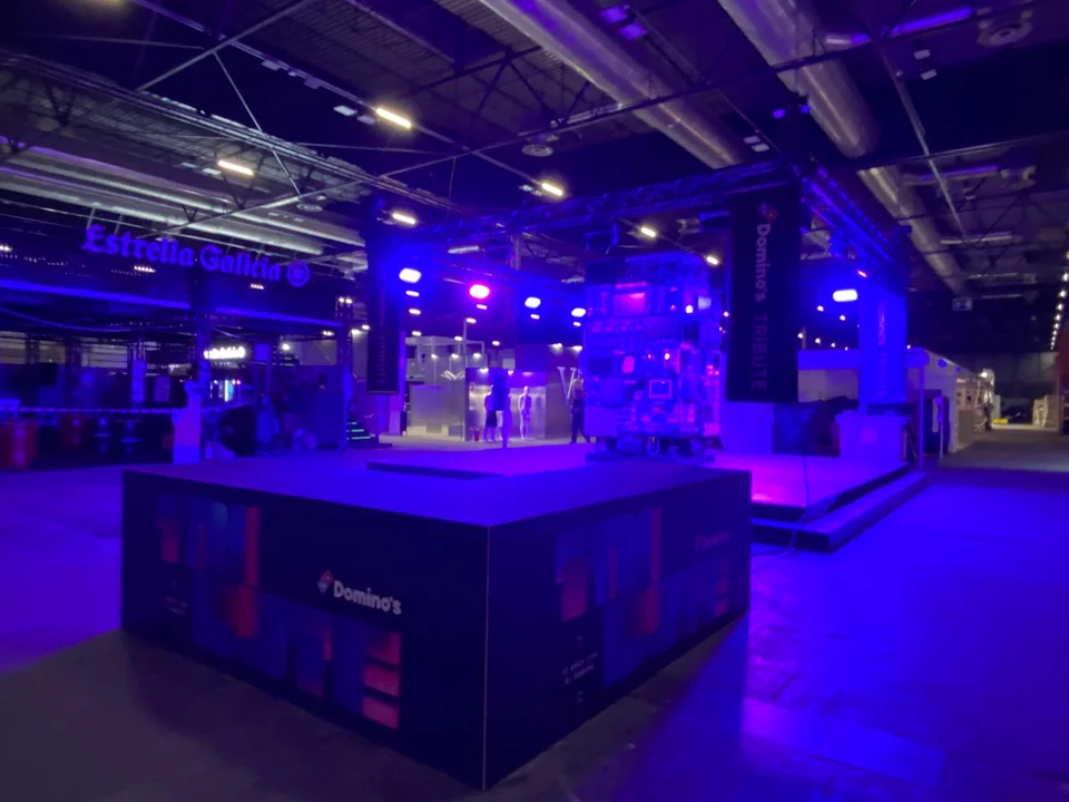 Mostrador de atención y estructura expositiva con iluminación azul en un pabellón