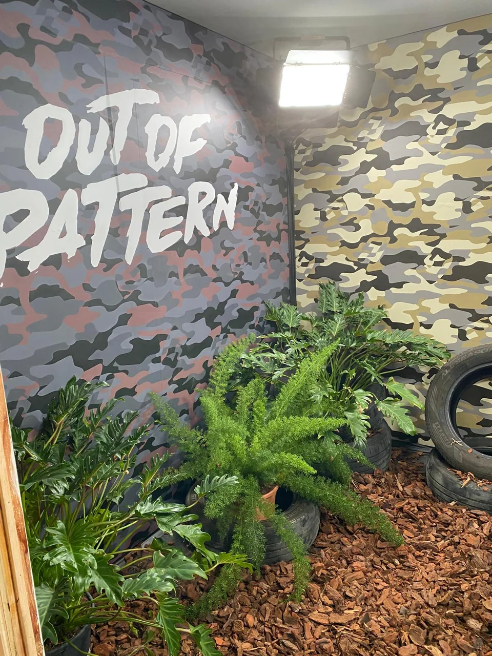 Detalle de gráfica con textura de camuflaje y vegetación en un stand
