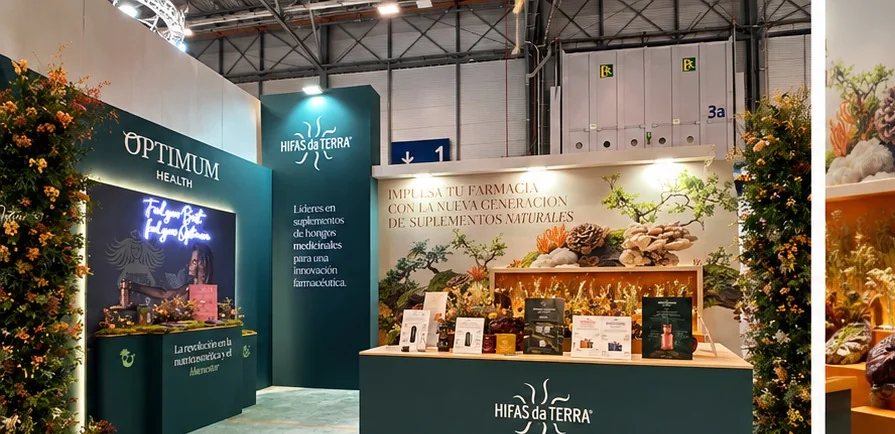 Stand con paneles verdes de marca, vegetación y mostrador iluminado