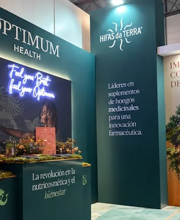 Detalle de paneles verdes de marca con iluminación y vegetación