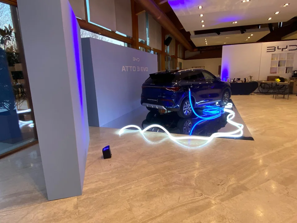 Presentación de un vehículo con iluminación azul y contorno luminoso en el suelo