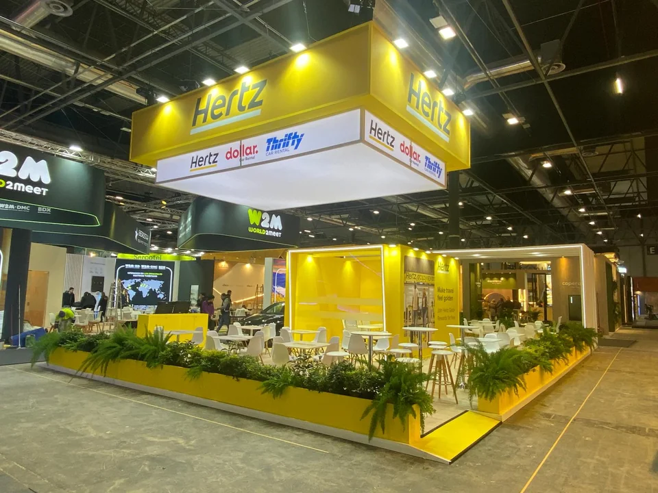 Stand amarillo con estructura superior, zonas abiertas y vegetación perimetral